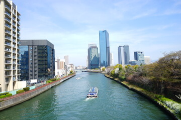 Fototapeta premium Osaka skyline along with Neya river (Neyagawa) in Japan . Panoramic view. - 日本 大阪府 寝屋川 大阪のビル 水上バス