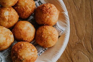 Top view of deep fried cheese ball on wood bowl