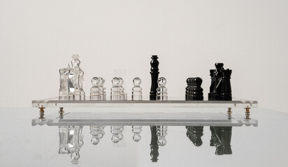 Black king surrounded of white glass pieces with reflection