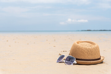 fashion hat and sunglasses on sandy beach