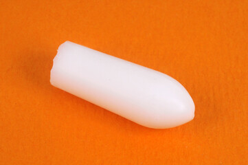 Concept de constipation un suppositoire sur fond orange