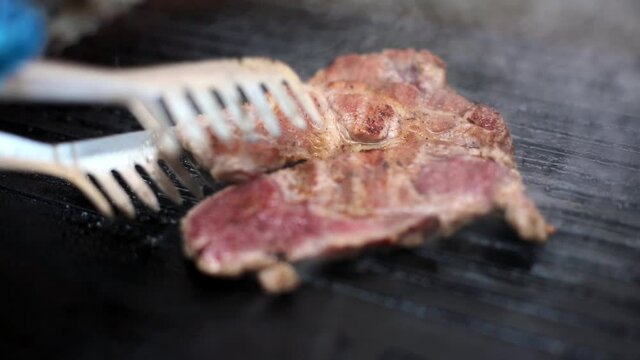 Close up footage of a slice of beef roasted on a barbecue grill.
