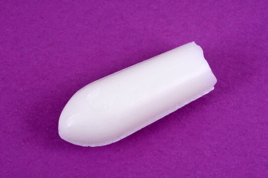 Concept de constipation un suppositoire sur fond rose