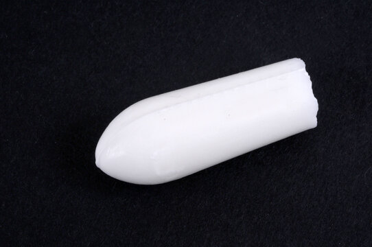 Concept de constipation un suppositoire sur fond noir