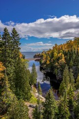 Fototapeta na wymiar Autumn colored trees along the Baptism River where it meets Lake Superior at Tettegouche State Park, Minnesota