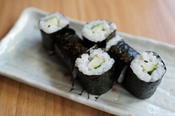 Cucumber sushi rolls served on a white ceramic plate.