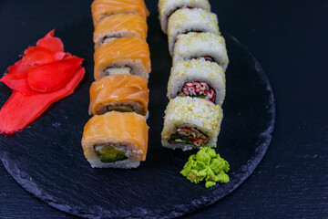 Set of sushi rolls on a black stone slate
