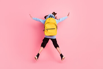 Full length body size rear back behind view of nice girl jumping new academic school year isolated over pink pastel color background