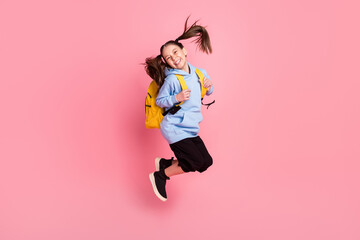 Full length body size photo of jumping girl with yellow backpack laughing isolated pastel pink...