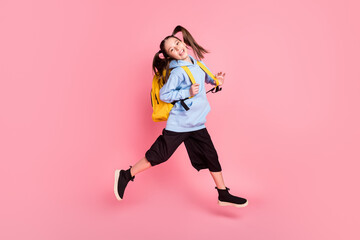 Fototapeta na wymiar Full length body size photo of jumping girl with yellow backpack wearing sport wear isolated pastel pink color background