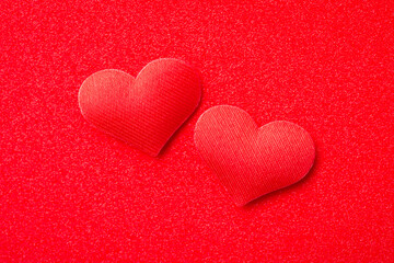 Obraz premium Top view of two red decorative hearts on red background. Passion, love, strong emotions concept.