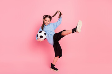 Full length body size photo of schoolgirl in sport outfit keeping ball practising karate isolated...