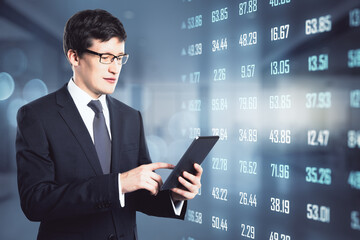 Amazed businessman holding a laptop in his hands with numbers nearby. Value and price management concept