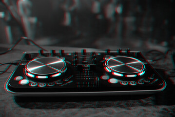DJ console for mixing music with blurry people dancing at a nightclub party. Black and white with...