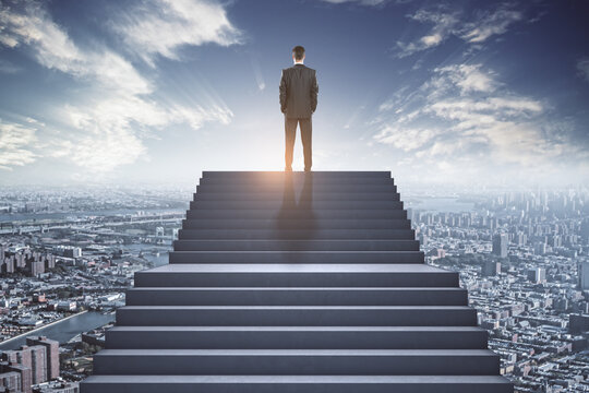 Success concept with businessman back on the top of stairway on megapolis city background