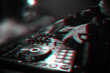 DJ console for mixing music with hands and with blurred people at a night club. Black and white...