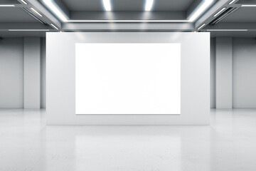 Blank white poster on light grey concrete partition in empty industrial hall with led lamps on top...