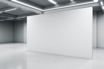 Empty big white room with a white blank concrete wall in the middle, artificially lighted, showroom and exhibition interior design concept, 3d rendering, mock up