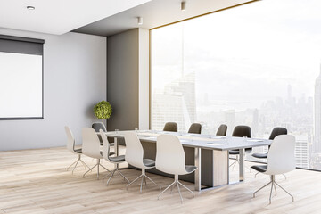 SIde view on big conference table in modern meeting room on high floor with great city view through...