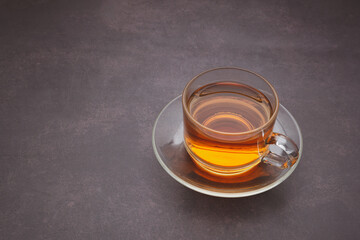 Teacup on a dark brown background. Space for text. Morning beverage and relaxation concept