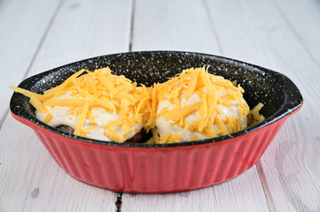 Two minced meat patties are placed in a red baking bowl