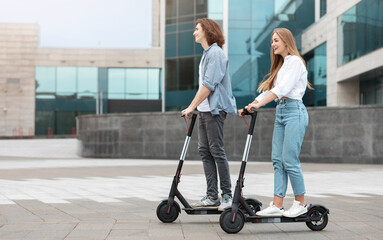 Young guy and lady having ride on electric kick scooter © Prostock-studio