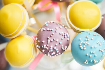 cake pops of yellow, blue and lilac color top view. round candy on a stick