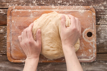 Making bread. Hands knead the dough.
