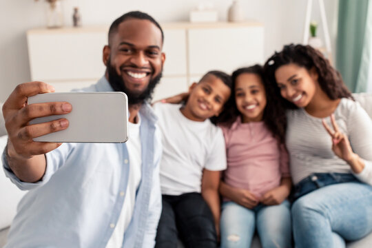 Portrait of black family taking selfie together at home