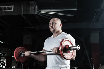 Male athlete lifts the barbell