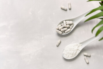 Collagen powder and pills on a gray background with a copy space. Natural beauty and health...