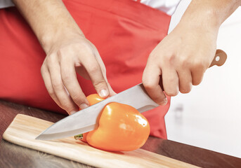 Chef hands cutting red fresh pepper