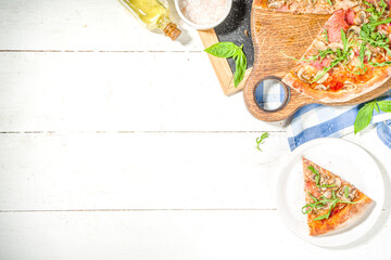 Tasty Italian traditional pizza with ham and mushrooms, on white wooden background. Mediterranean food recipe concept, top view