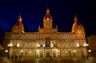 Fotografía nocturna de un edificio histórico muy bien iluminado en la ciudad de La Coruña, España