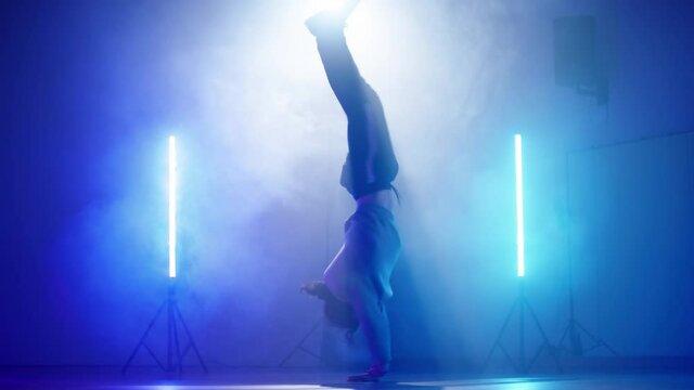 Cyber dancer cool hand spin break-dance in futuristic smoke lights slowmo 4K