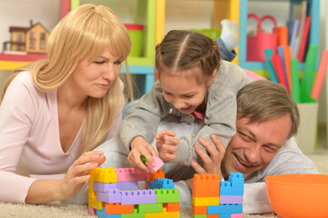 Happy family with child playing with toy blocks