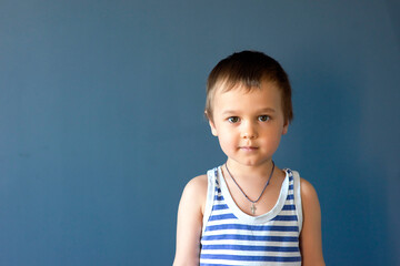 Happy child. Portrait of a beautiful boy in a vest, smiling, isolated on a blue background. selective focus