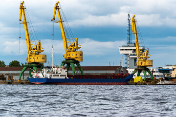 Fototapeta premium Coal industry. Yellow working coal cranes in the industrial port.