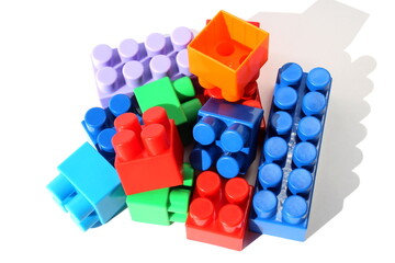 Children's bright toys in the form of blocks lie in one heap for construction.