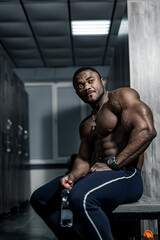 Fototapeta na wymiar Muscular man african bodybuilder. Happy young african man drinking water after exercise.