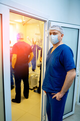 Fototapeta na wymiar Adult doctor surgeon standing near operating room with other workers in hospital.