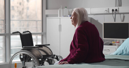 Back view of senior woman sitting in hospital bed