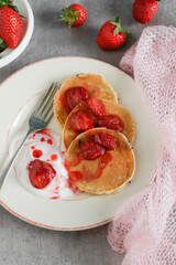 
Homemade rustic pancakes stack with strawberry jam and yogurt