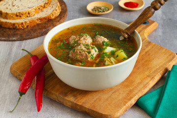 
Homemade rustic soup with  meatballs, potatoes and vegetables. selective focus