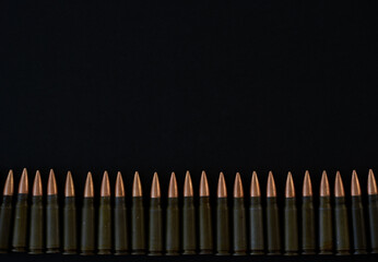 Cartridges for AKM 7.62x39 folded in a line on a black background