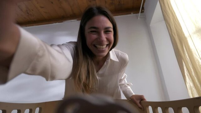POV shot of young mother giving pacifier to her newborn baby and playing with he while lying in a crib by in a nursery. Concept of family, love,care, parenthood, childhood, life, maternity, motherhood