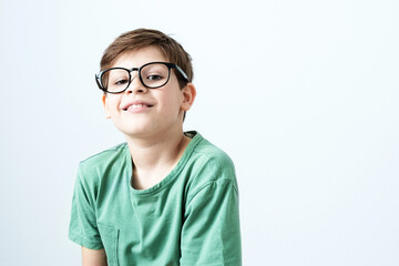 Smiling boy in a green T-shirt. Copy space. Schoolboy looking at camera 