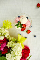 Tasty Ice cream and fresh blueberries, strawberry in the bowl, presented with flower