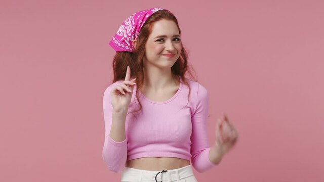 Redhead young fun attractive woman 20s years old in rose clothes bandana look camera pointing fingers herself ask say who me no thanks i do not need it isolated on pastel pink color background studio