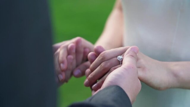closeup of bride and groom exchanging wedding rings 